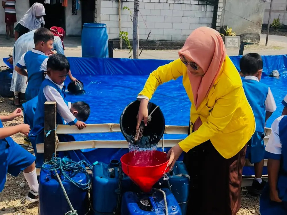 Foto salah satu mahasiswa UT Salut Kartini Rembang, membantu mendistribusikan air bersih (Aflia Dwi)